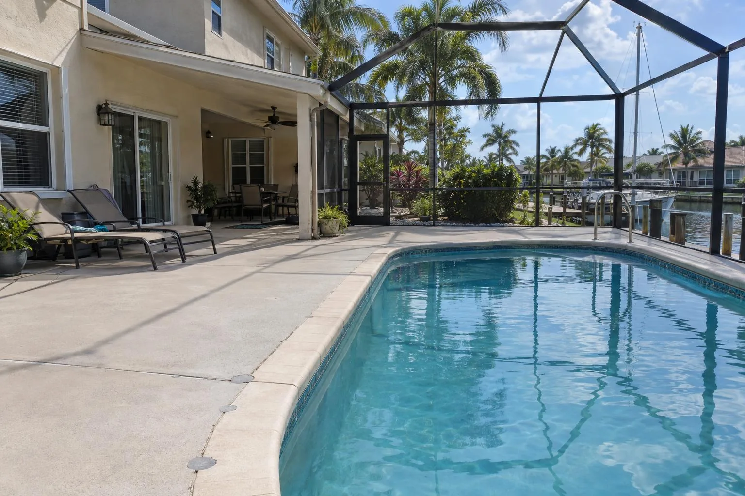 A level concrete pool deck beside a screened pool